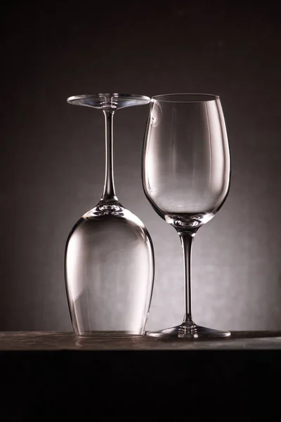 Two reversed empty wineglasses on black — Stock Photo