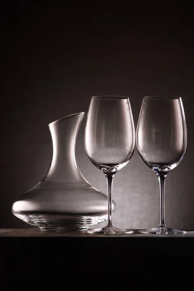 Still life of empty decanter and wineglasses on black — Stock Photo