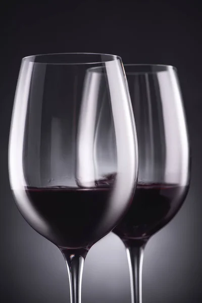 Gros plan des verres de délicieux vin rouge sur noir — Photo de stock