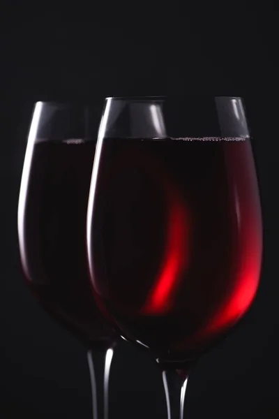 Close-up de copos cheios de vinho tinto de luxo em preto — Fotografia de Stock