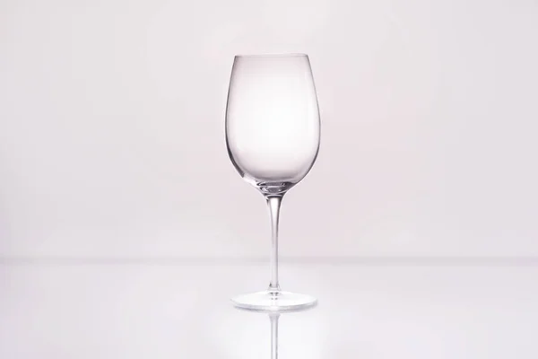 Verre à vin vide sur surface réfléchissante et sur fond blanc — Photo de stock