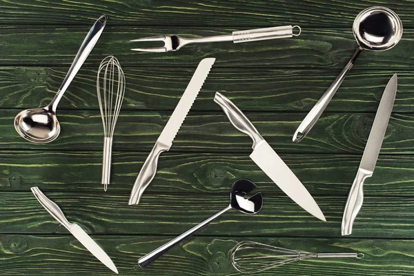 Vista superior de utensílios de cozinha metálica em mesa de madeira — Fotografia de Stock