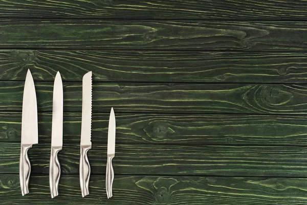 Top view of different types of knifes on wooden table — Stock Photo