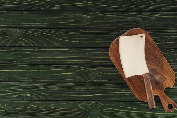 Vue de dessus de hache de boucher sur planche à découper en bois sur table — Photo de stock