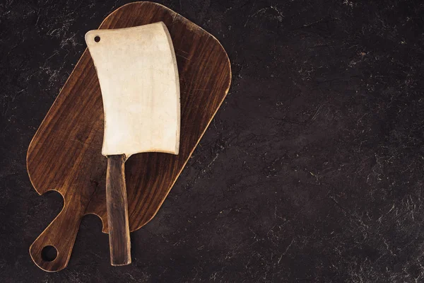 Top view of butcher axe on wooden cutting board on marble table — Stock Photo