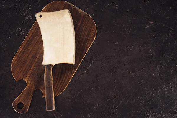 Vue de dessus de hache de boucher sur planche à découper en bois sur table en marbre — Photo de stock