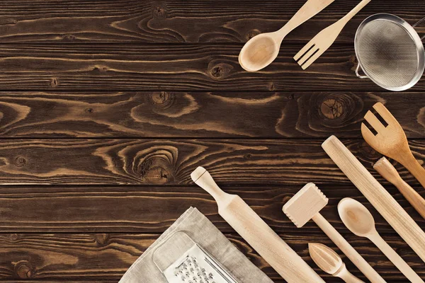 Vue de dessus des ustensiles de cuisine disposés, sac et râpe sur table en bois — Photo de stock