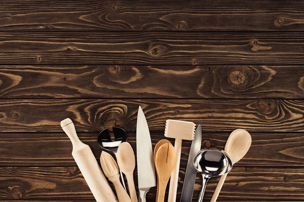 Blick von oben auf arrangierte Küchenutensilien auf Holztisch — Stockfoto