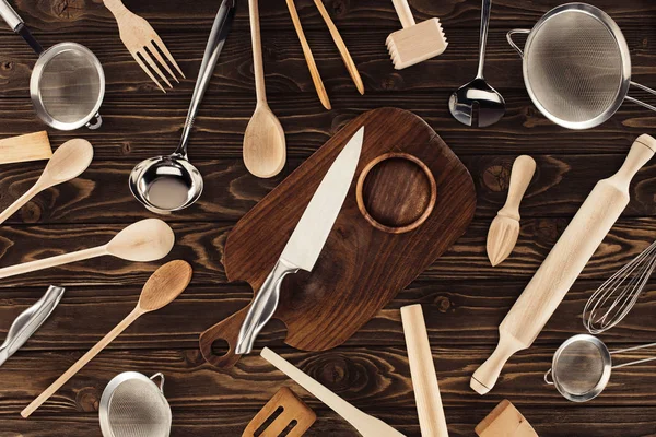 Blick von oben auf verschiedene Küchenutensilien auf Holztisch — Stockfoto