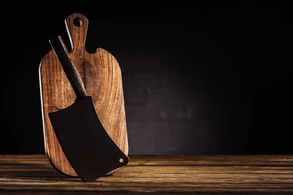 Closeup view of wooden cutting board and butcher axe on table — Stock Photo