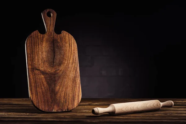 Plano de primer plano de rodillo y tabla de cortar de madera en la mesa - foto de stock