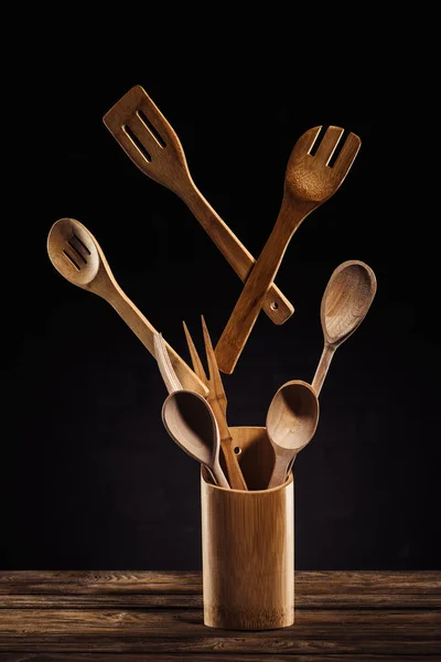 Falling kitchen utensils on wooden table — Stock Photo