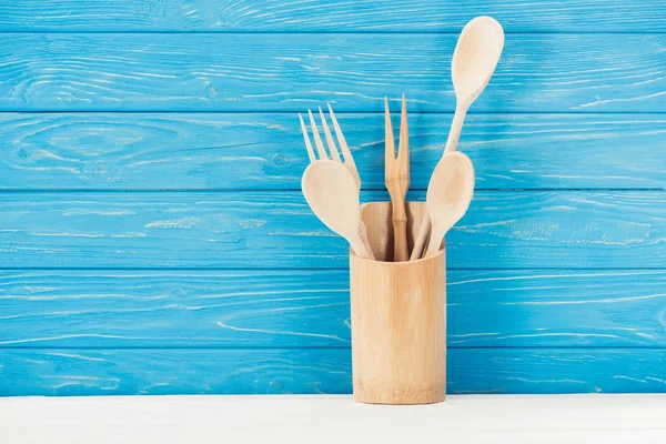 Primer plano de utensilios de cocina frente a la pared de madera azul - foto de stock