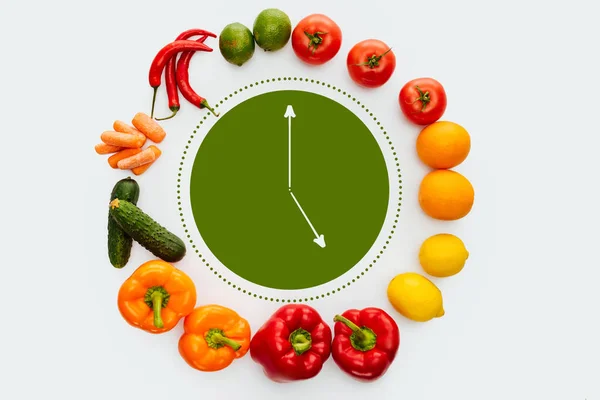 Top view of circle of vegetables and fruits with green clock inside isolated on white — Stock Photo