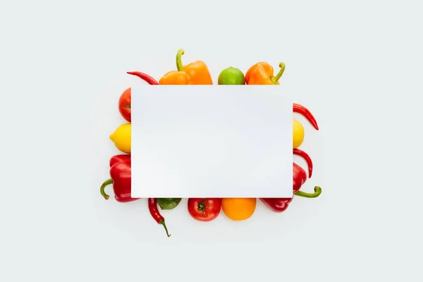 Vista superior del cartel en blanco sobre verduras y frutas aisladas sobre blanco - foto de stock