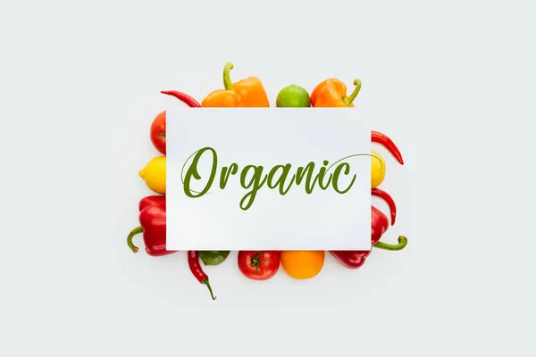 Vista superior de la hoja de papel con texto Orgánica sobre verduras y frutas aisladas sobre blanco - foto de stock