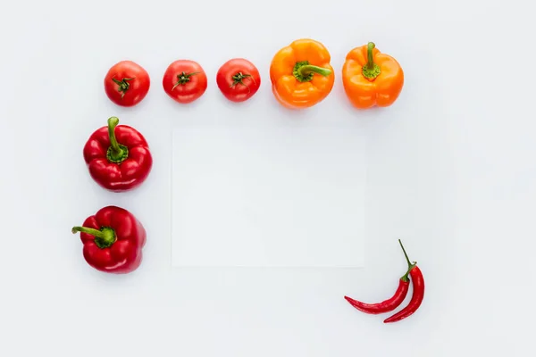 Vista superior do quadro de vegetais vermelhos e laranja isolados em branco — Fotografia de Stock