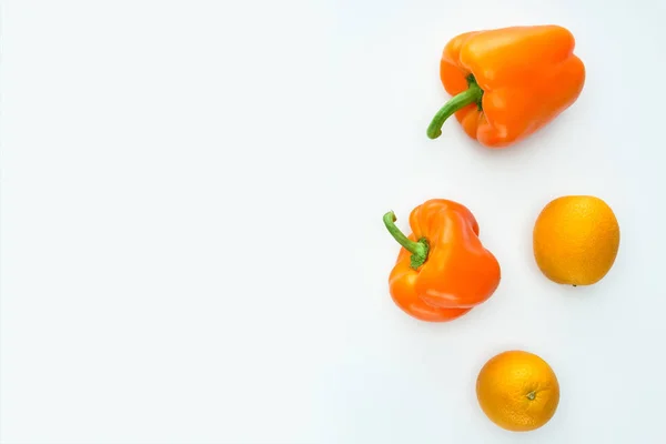 Top view of orange bell peppers and oranges isolated on white — Stock Photo