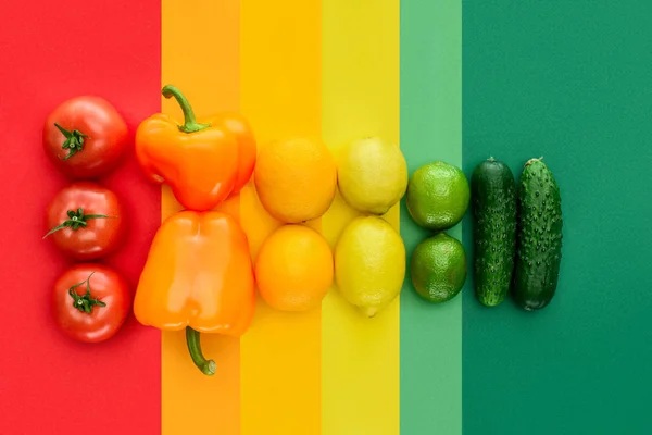 Vista superior de tomates maduros, limões e pepinos na superfície colorida — Fotografia de Stock