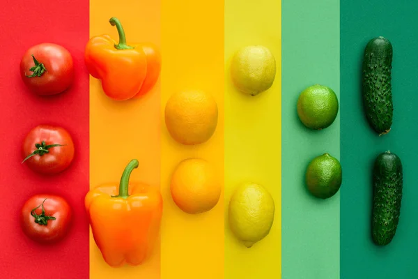 Vista superior de pimentas maduras, laranjas e limas na superfície colorida — Fotografia de Stock