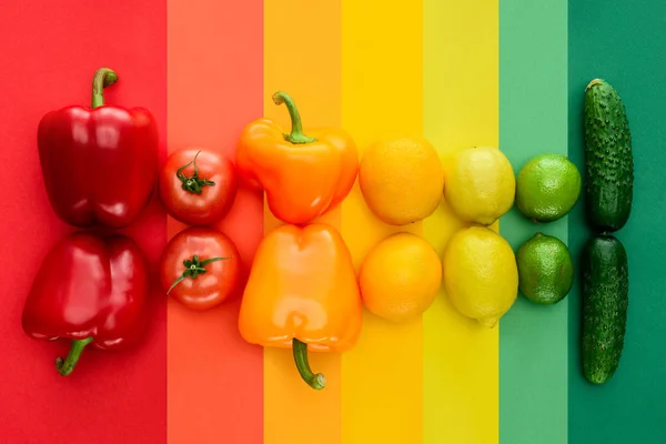 Top view of ripe fruits and vegetables on rainbow surface — Stock Photo