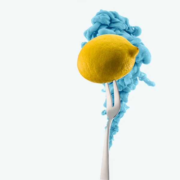 Lemon on fork and blue ink isolated on white — Stock Photo