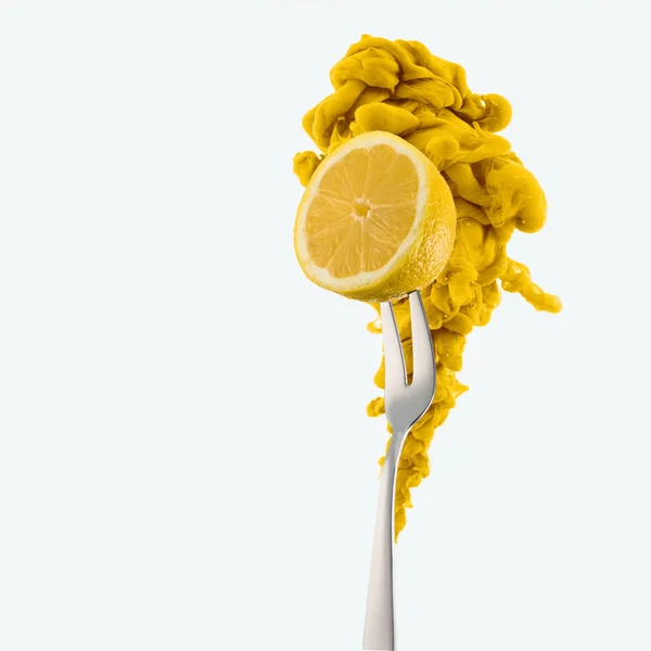Zitronenhälfte auf Gabel und gelbe Tinte isoliert auf Weiß — Stockfoto