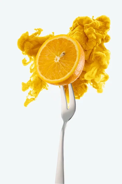 Half of orange on fork and yellow ink isolated on white — Stock Photo