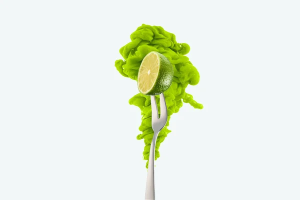 Half of lime on fork and green ink isolated on white — Stock Photo