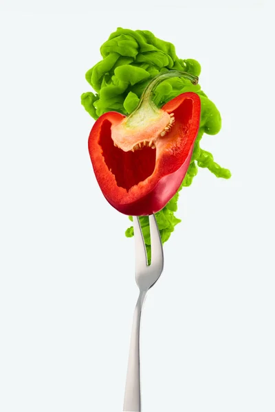 Half of red bell pepper on fork and green ink isolated on white — Stock Photo