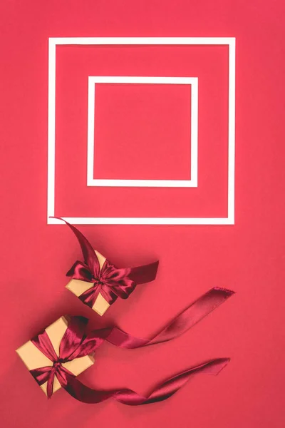 Top view of gift boxes and frames on red surface — Stock Photo