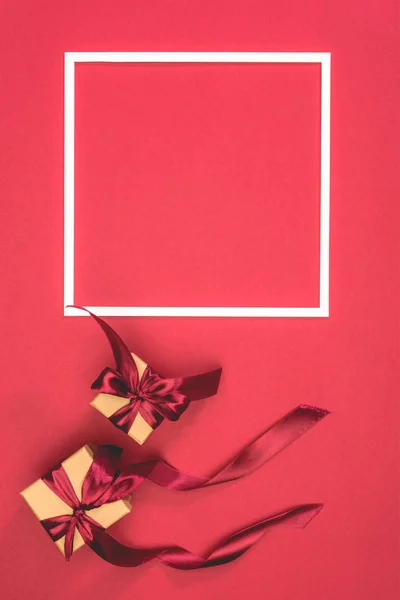 Vista elevata di scatole regalo e cornice sulla superficie rossa — Foto stock