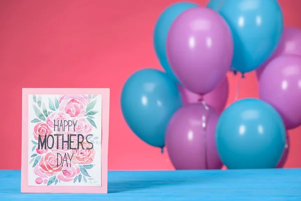 Carte postale avec texte Happy Mothers Day et bleu avec des ballons violets sur fond — Photo de stock