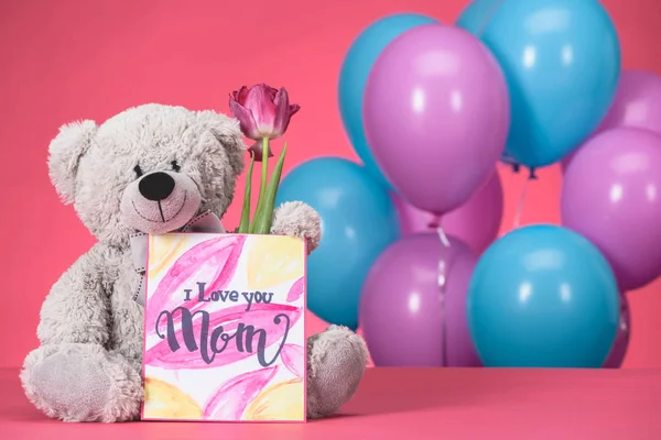 Teddy bear with pink tulip and postcard with text I Love You Mom, mothers day concept — Stock Photo