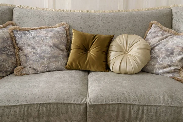 Velvet pillows on grey sofa in room — Stock Photo