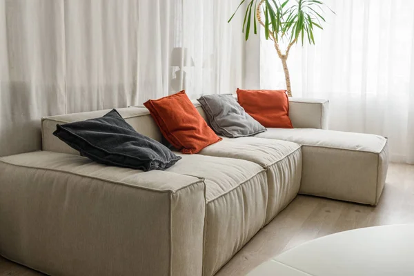 Almohadas rojas y grises en el acogedor sofá de la habitación - foto de stock