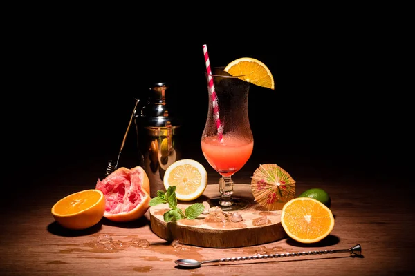 Bebida alcoólica em tábua de madeira com frutas na mesa — Fotografia de Stock