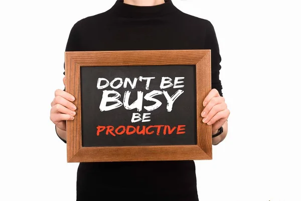 Cropped image of woman holding wooden board with inscription dont be busy be productive isolated on white — Stock Photo