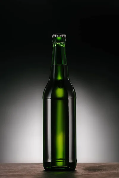 Close up view of bottle of beer on dark grey backdrop — Stock Photo