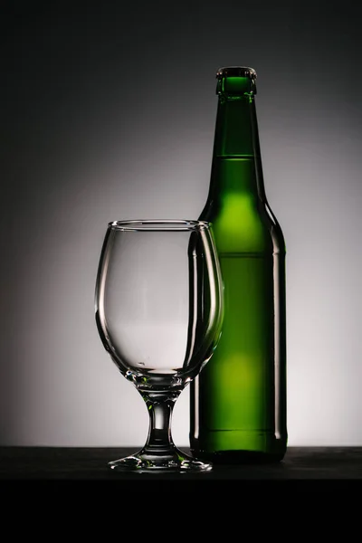 Close up vista de garrafa de cerveja e vidro na superfície no fundo — Fotografia de Stock