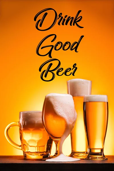 Close up view of arranged mugs of cold beer with froth and drink good beer inscription on orange background — Stock Photo