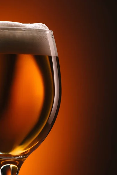 Закрыть вид на кружку пива на оранжевом заднике — стоковое фото