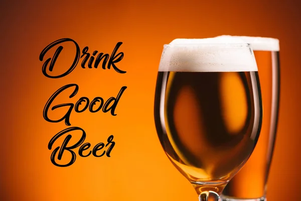 Close up view of arrangement of glasses of beer and drink good beer inscription on orange backdrop — Stock Photo