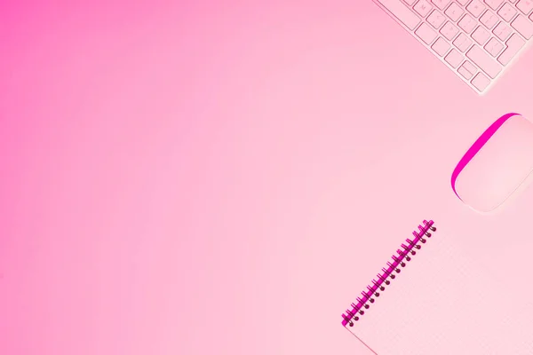 Pink toned picture of textbook, computer mouse and keyboard on table — Stock Photo