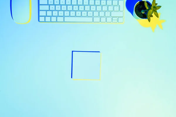 Blue toned picture of computer keyboard and mouse, plant ant sticky note — Stock Photo