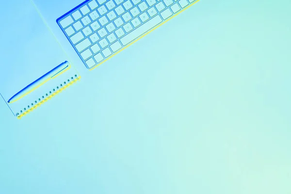 Imagen tonificada azul del teclado de la computadora, libro de texto vacío y pluma - foto de stock