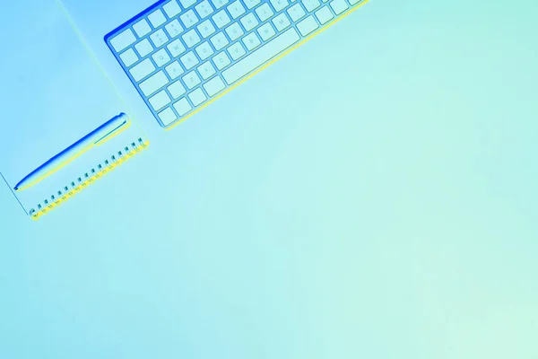 Blue toned picture of computer keyboard, empty textbook and pen — Stock Photo