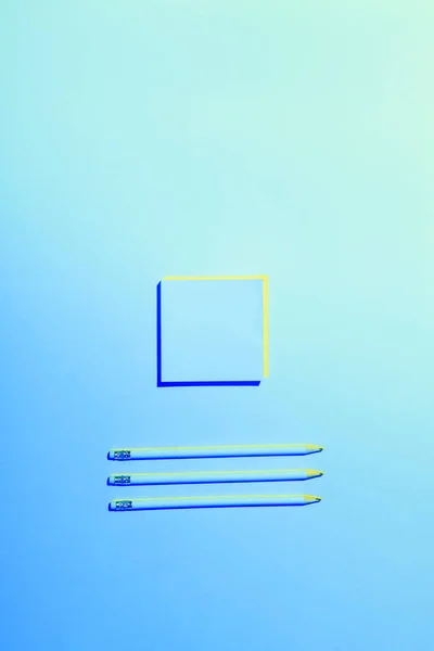 Blue toned picture of sticky note and three pencils placed in row — Stock Photo