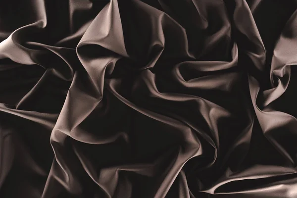 Full frame of folded dark silk cloth as background — Stock Photo