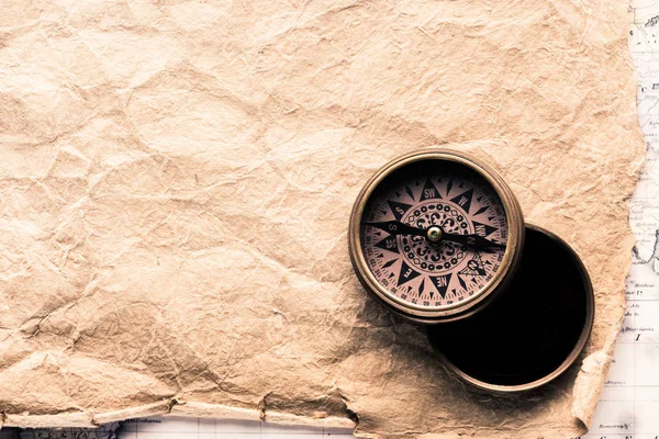 Top view of vintage navigation compass on blank crumpled paper — Stock Photo